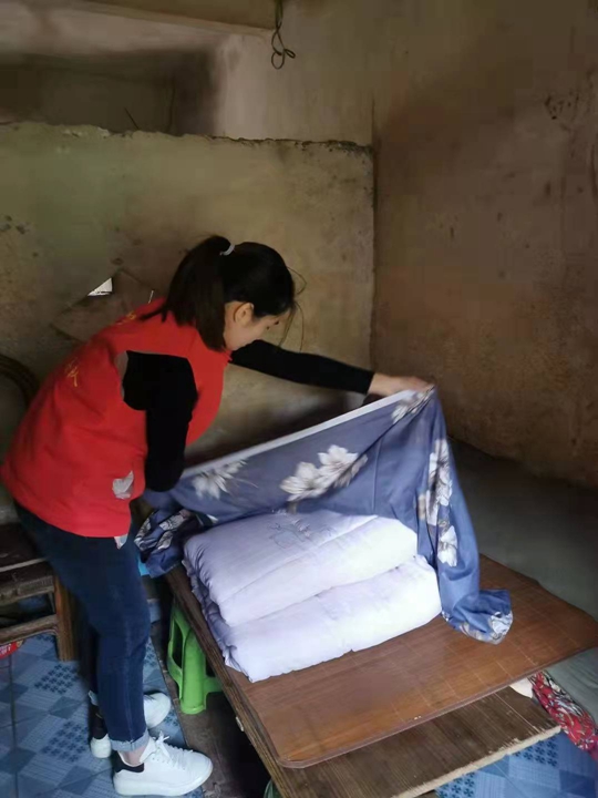 党员志愿者细心为群众入棉被.jpg