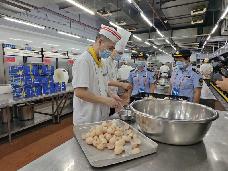 图为驻点人员检查蛋类清洗制作过程.jpg
