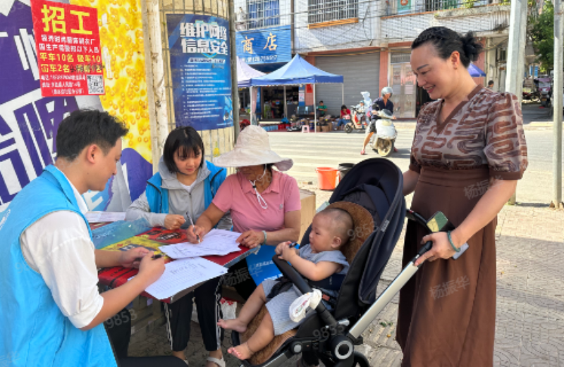 （图二·协助有意愿做志愿者的群众填写申请表）