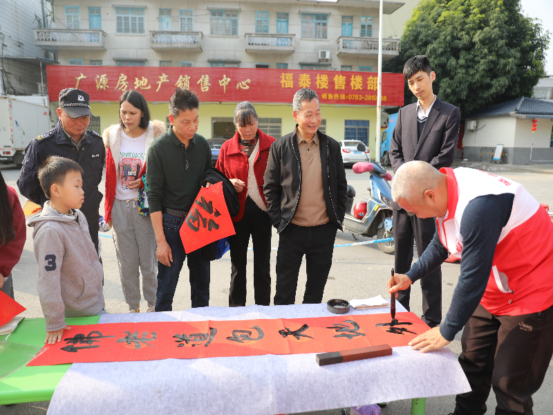 英德市书法协会会员邓南映、本土书法家吴光煌书写春联吸引众多群众驻足欣赏1.jpg
