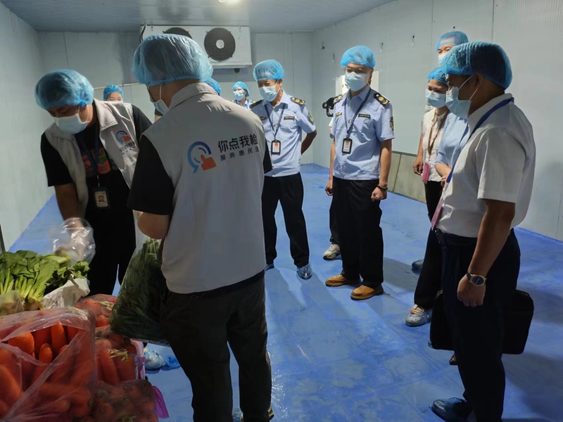 图为代表们现场监督检验机构工作人员进行取样抽检.jpg